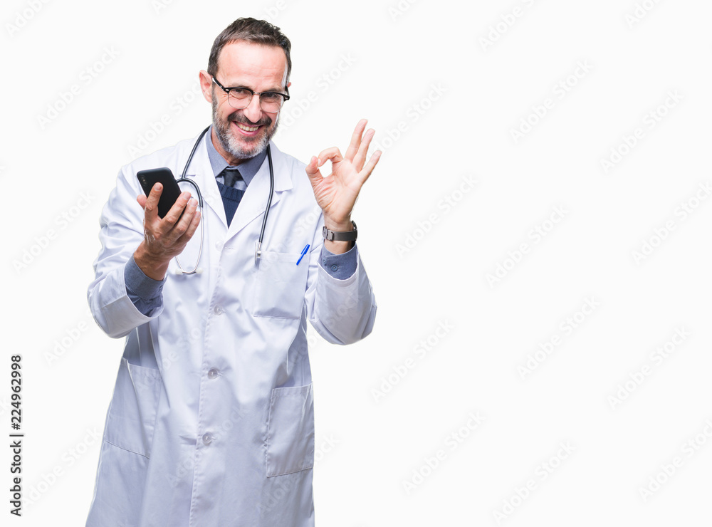 Middle age senior hoary doctor man texting using smartphone over isolated background doing ok sign with fingers, excellent symbol Middle age senior hoary doctor man texting using smartphone over isolated background doing ok sign with fingers, excellent symbol