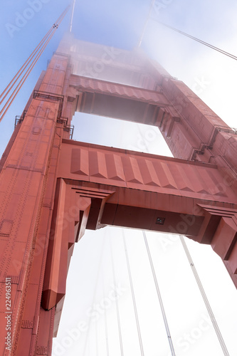 Golden Gate Bridge tower in the fog, looking up from the base. San Francisco, California, USA.