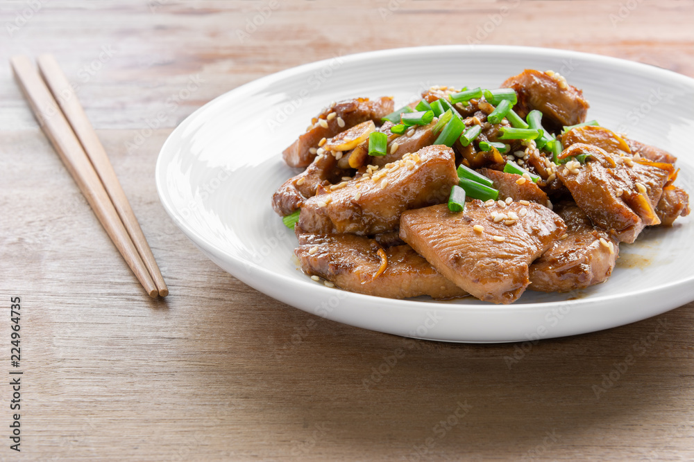 close up of stir fried chicken with black soy sauce in a ceramic dish on wooden table. asian homemade style food concept. close up of stir fried chicken with black soy sauce in a ceramic dish on wooden table. asian homemade style food concept.