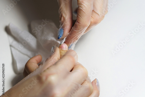 Professional manicure for child. Beautician cleans dirt from under finger nails of child. Shooting close-up.