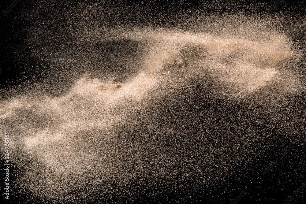 Fototapeta premium Dry river sand explosion. Golden colored sand splash against black background.