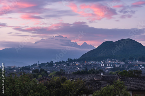 Rooftops in Lijiang old town, the UNESCO world heritage in Yunnan with jade dragon snow mountains in the background at sunset