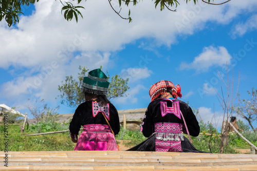 Back side of two kids sitting on the table wood watching the view.