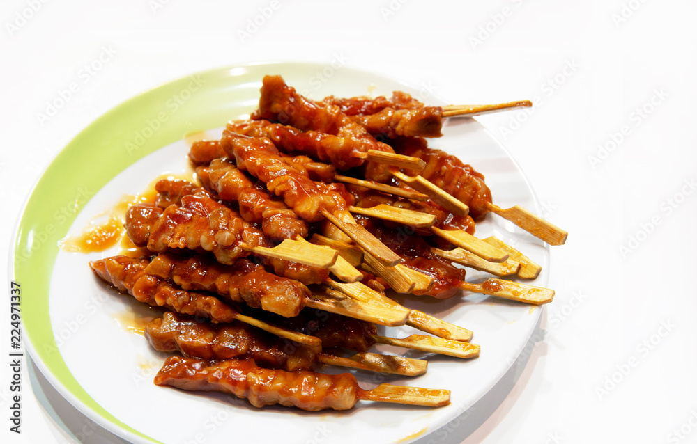 Grilled meat on white background, pork skewers served on a plate