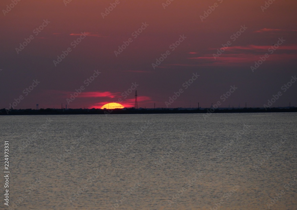 The sun halfway gone in in the horizon The sun halfway gone in in the horizon
