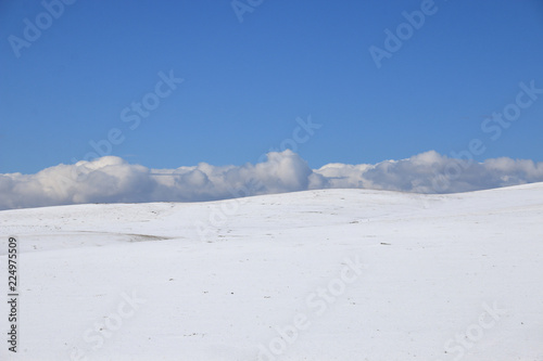 winter landscape. Snow slope, horizon, clouds