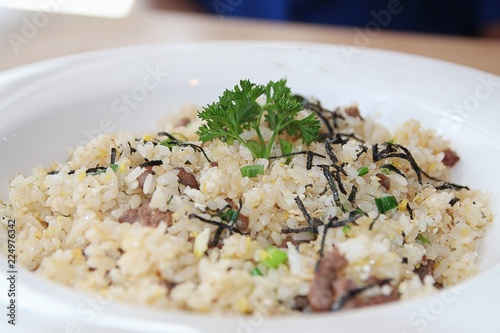 Oriental fried rice with corned beef, topped with green herbs 