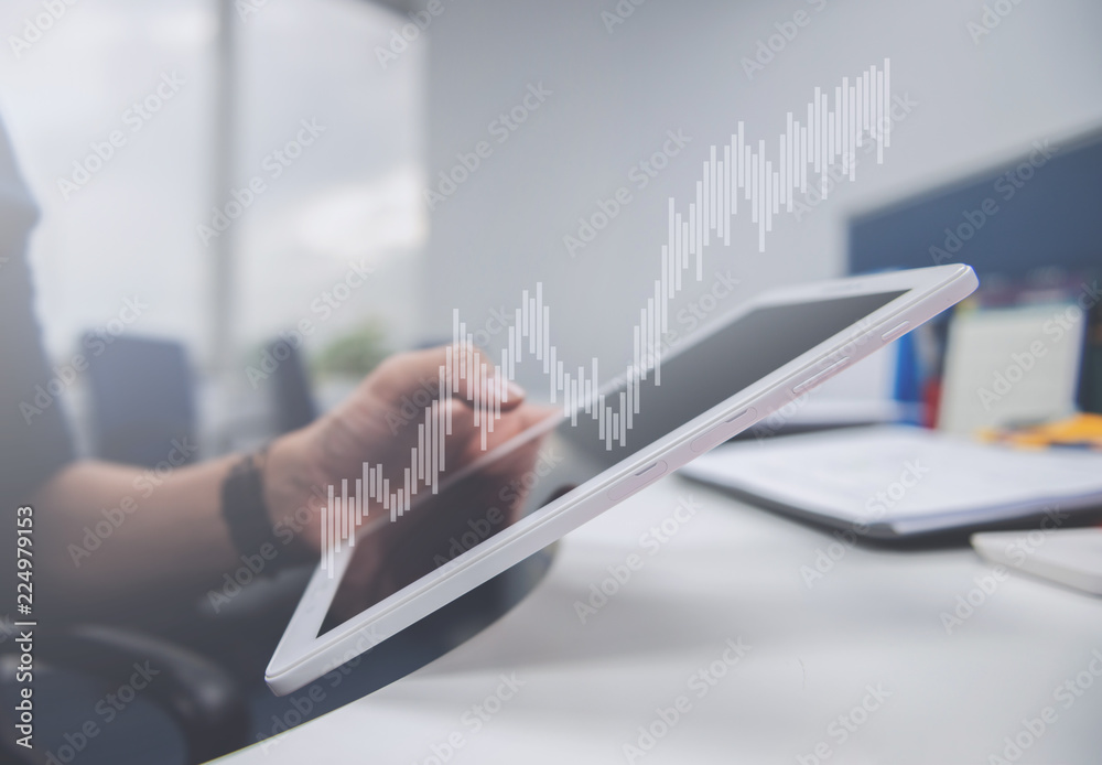 Naklejka premium Business man is holding the tablet, double exposure of candlestick chart for finance and trading