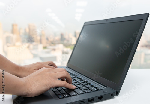 Woman hand is typing to the laptop keyboard