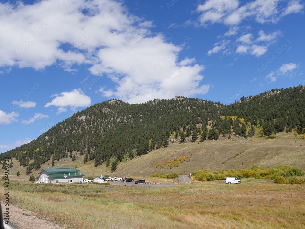  Countryside view with a building along the road in the mountains of Colorado on a bright day.