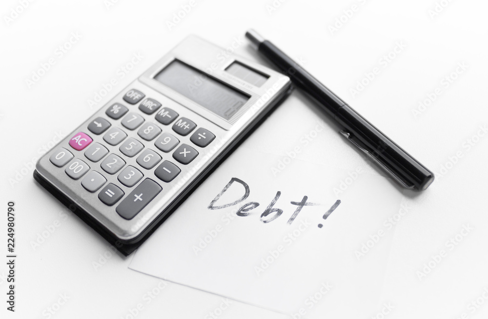 calculator with a pen and paper note with debt word isolated on white background calculator with a pen and paper note with debt word isolated on white background