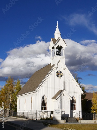 Wide portrait shot of a community Presbyterian church in Fairplay, Colorado, with beautiful clouds in the skies in the background