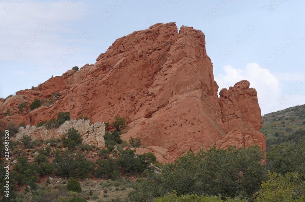Beautiful rock wall formation with trees and bushes at the Garden of the Gods, a National natural landmark in Colorado Springs, Colorado. Beautiful rock wall formation with trees and bushes at the Garden of the Gods, a National natural landmark in Colorado Springs, Colorado.