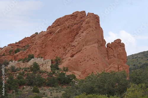 Beautiful rock wall formation with trees and bushes at the Garden of the Gods, a National natural landmark in Colorado Springs, Colorado.