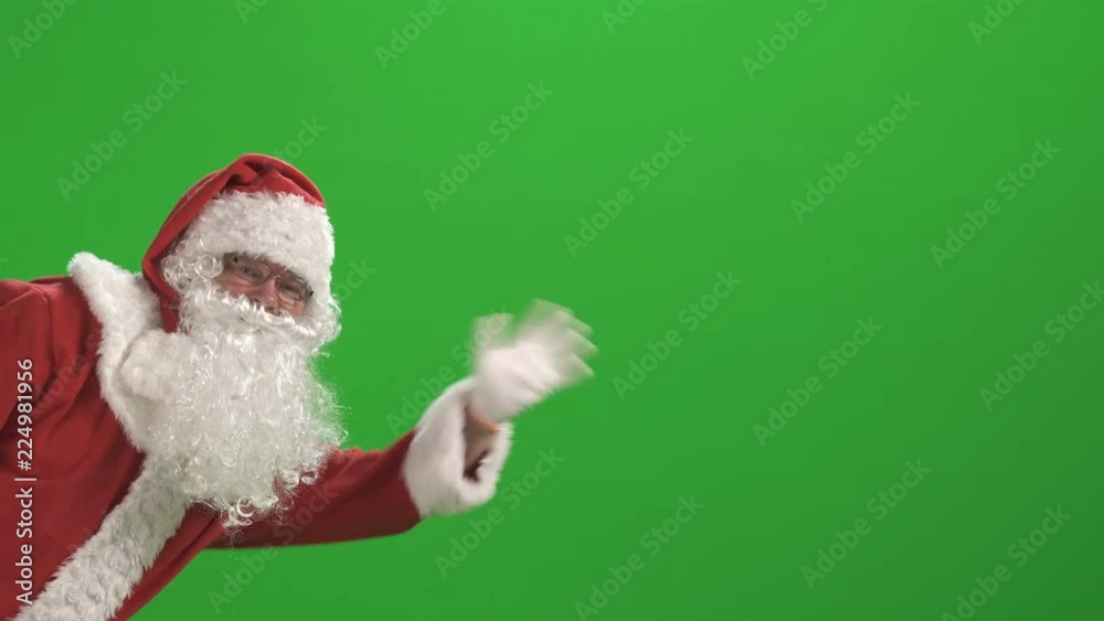 Merry Christmas. Santa Claus in a red suit waving his hand on a green ...