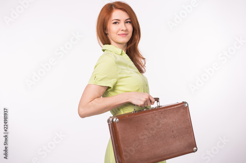 Young redhead woman with leather vintage suitcase on white background