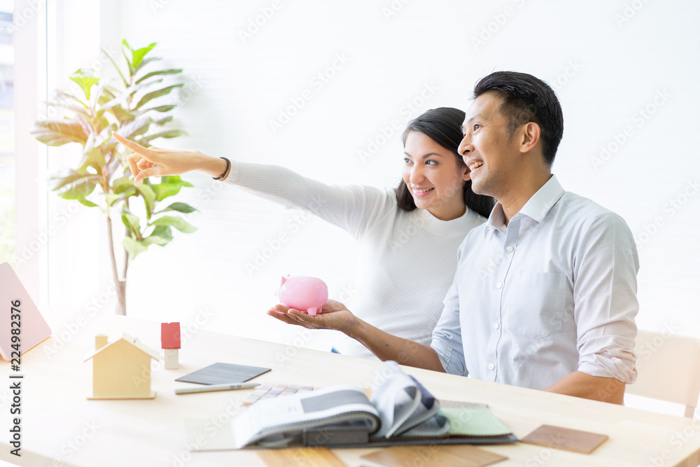 Obraz premium Happy couple plan buying house.Concept for Couple saving money for buy home and real estate. Select material for decorate furniture.