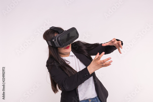 Technology and people concept - Amazed young woman touching the air during the VR experience