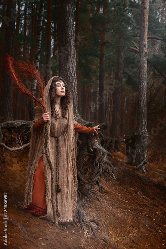 a witch in rags conjures in forest