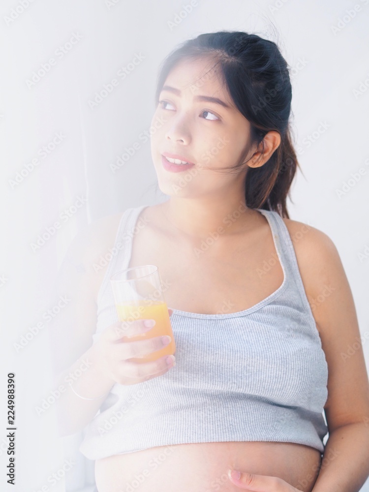 pregnant woman with a glass of orange juice pregnant woman with a glass of orange juice