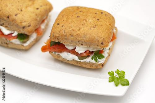 Sandwich with salmon, cheese and cereal bread on white background. Close up.