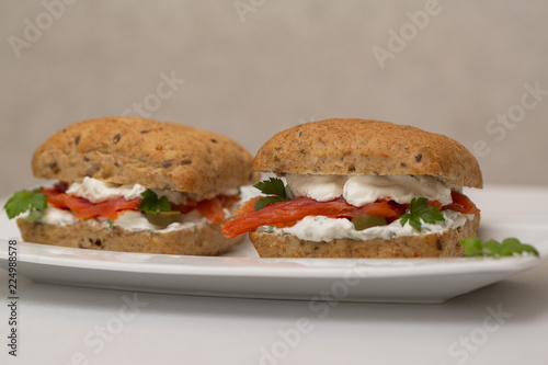 Sandwich with salmon, cheese and cereal bread on white background. Close up.