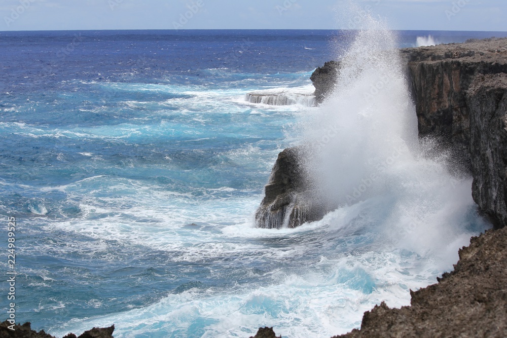 Forceful  giant waves smash against the steep cliffs of the As Matmos Fishing Cliff on Rota, Northern Mariana Islands