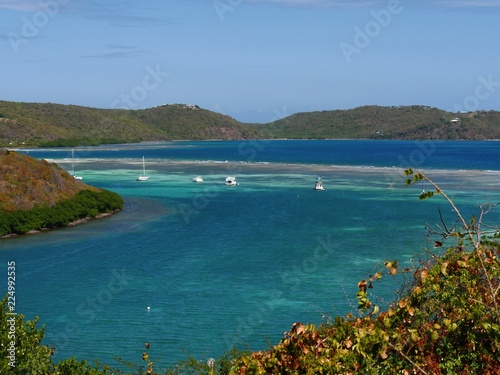 Medium close up of blue and green waters of Culebra with yachts and boats moored in the bay.