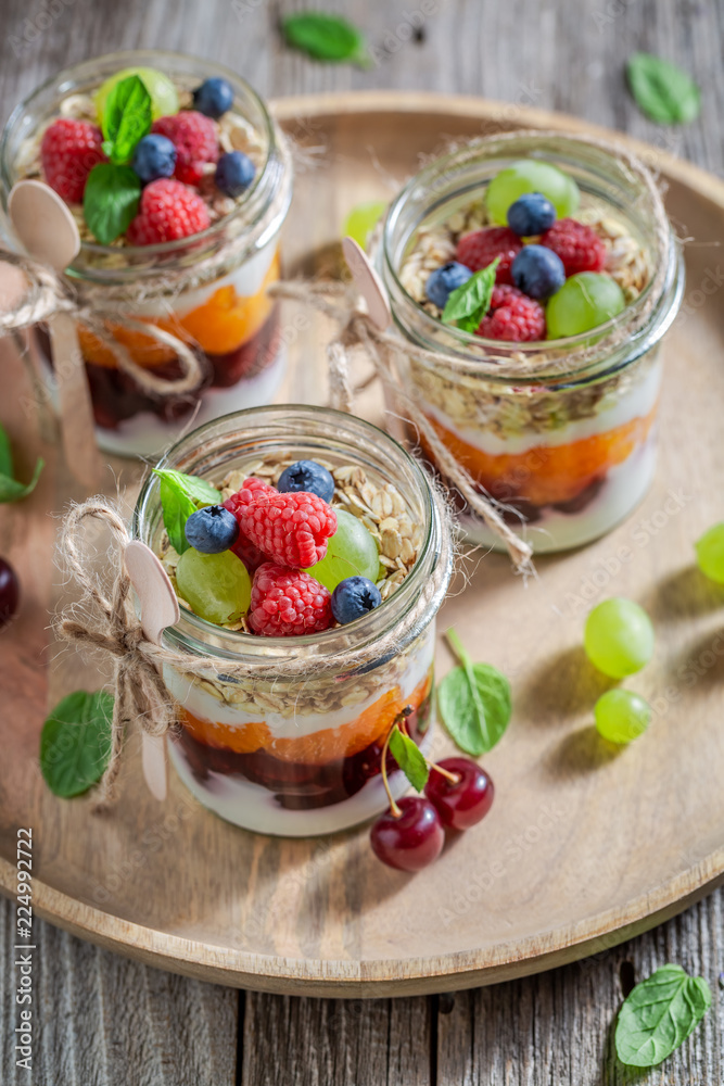 Healthy granola in jar with yoghurt and berry fruits Healthy granola in jar with yoghurt and berry fruits