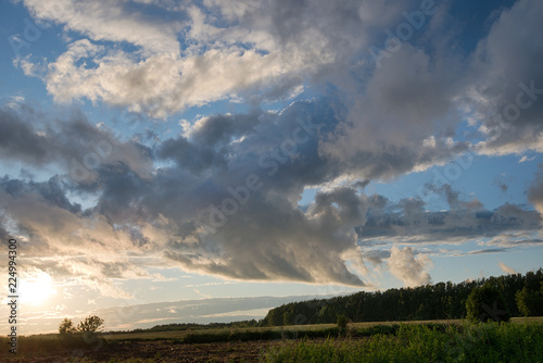 Clouds at sunset/ Clouds at sunset in a field after a rain