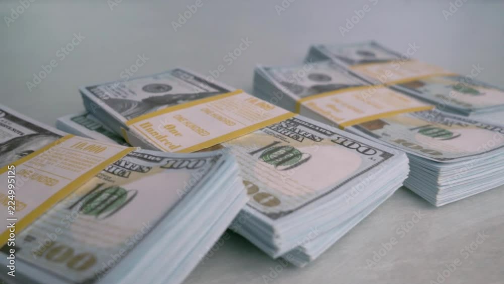 Bundles of Bank money fall down on the white table. Slow motion.
Bundles of Bank money fall down on the white table. Slow motion.