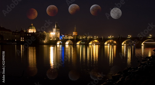 Canvas Print The Charles Bridge over the Vltava River, in Prague with total eclipse of moon