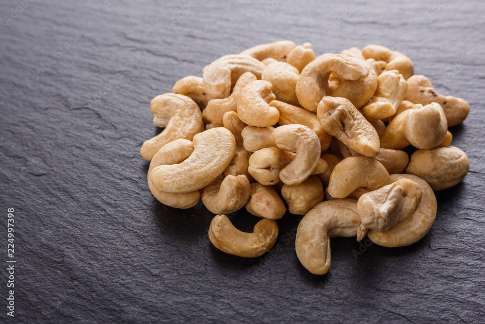 Fototapeta premium cashew nuts on a dark stone background