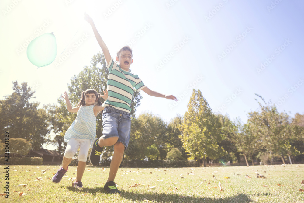 Kids playing with a balloon in the park. Children having fun outdoors concept
