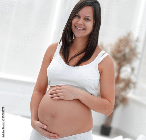 portrait of young pregnant woman on a light background. Free Download portrait of young pregnant woman on a light background. - GFXLoad