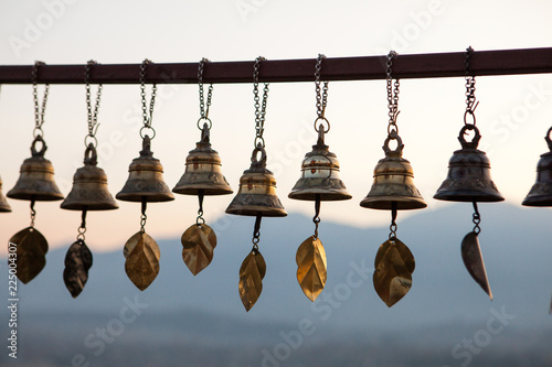 Prayer Bells at Svayambunath Stupa in Kathmandu, Nepal with Himalayas on background at sunset photo