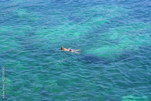 aerial view of swimming girl in the blue sea 