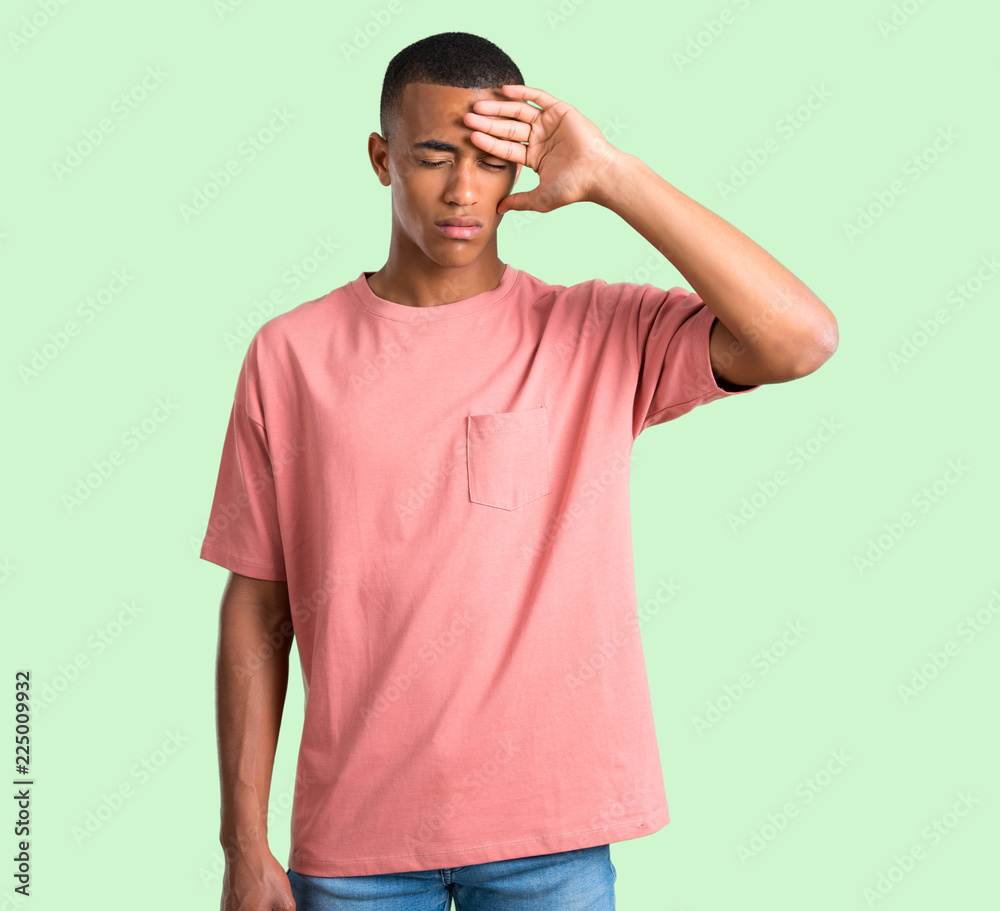 Dark skinned man with tired and sick expression on green isolated background Dark skinned man with tired and sick expression on green isolated background