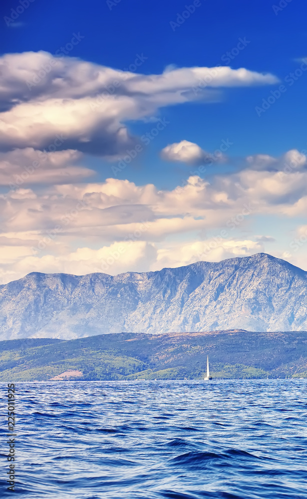 Beautiful sea landscape, sailboat sailing on the distance on great majestic mountains background, romantic cruise in the Adriatic sea, Croatia