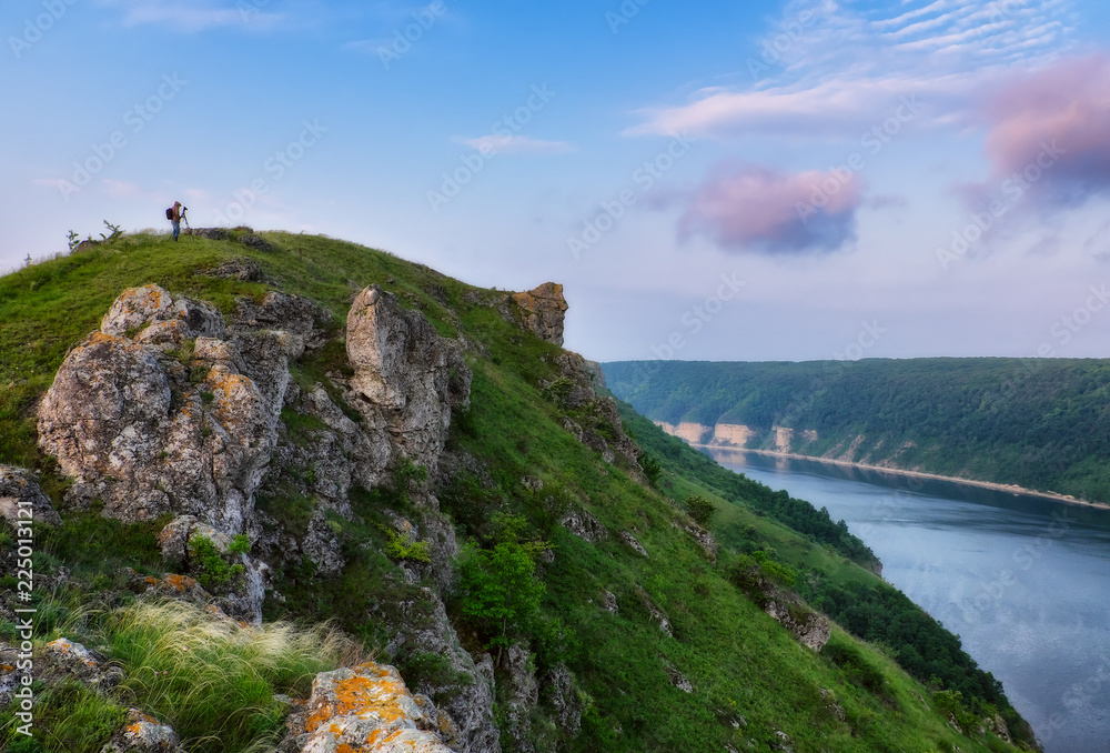 Naklejka premium man on a rock above a river. the tourist looks at the canyon