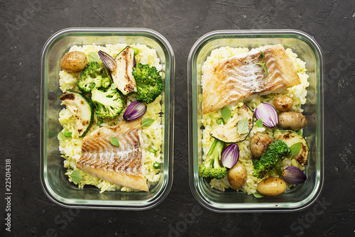 A healthy meal for a snack is a lunch box. Glass containers with fresh steam sea fish, rice with turmeric, fresh vegetables, olives, broccoli. Top View.