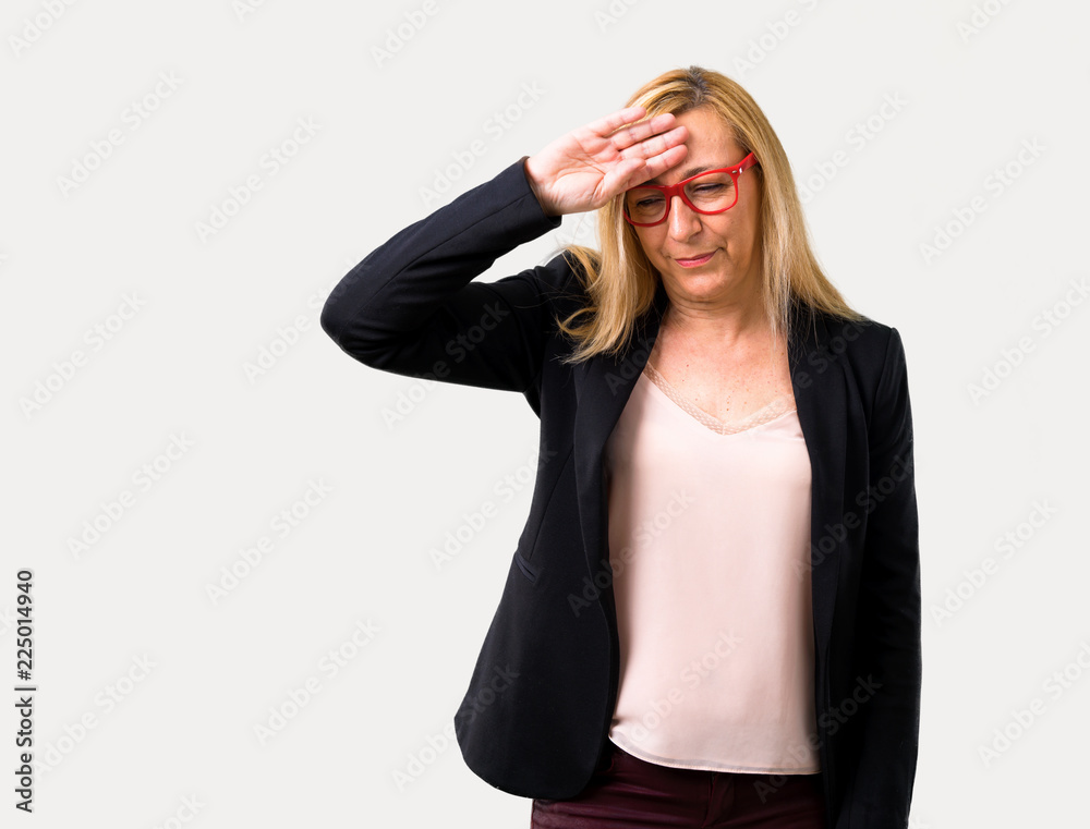 Middle-age blonde business woman with black jacket with tired and sick expression on isolated grey background Middle-age blonde business woman with black jacket with tired and sick expression on isolated grey background