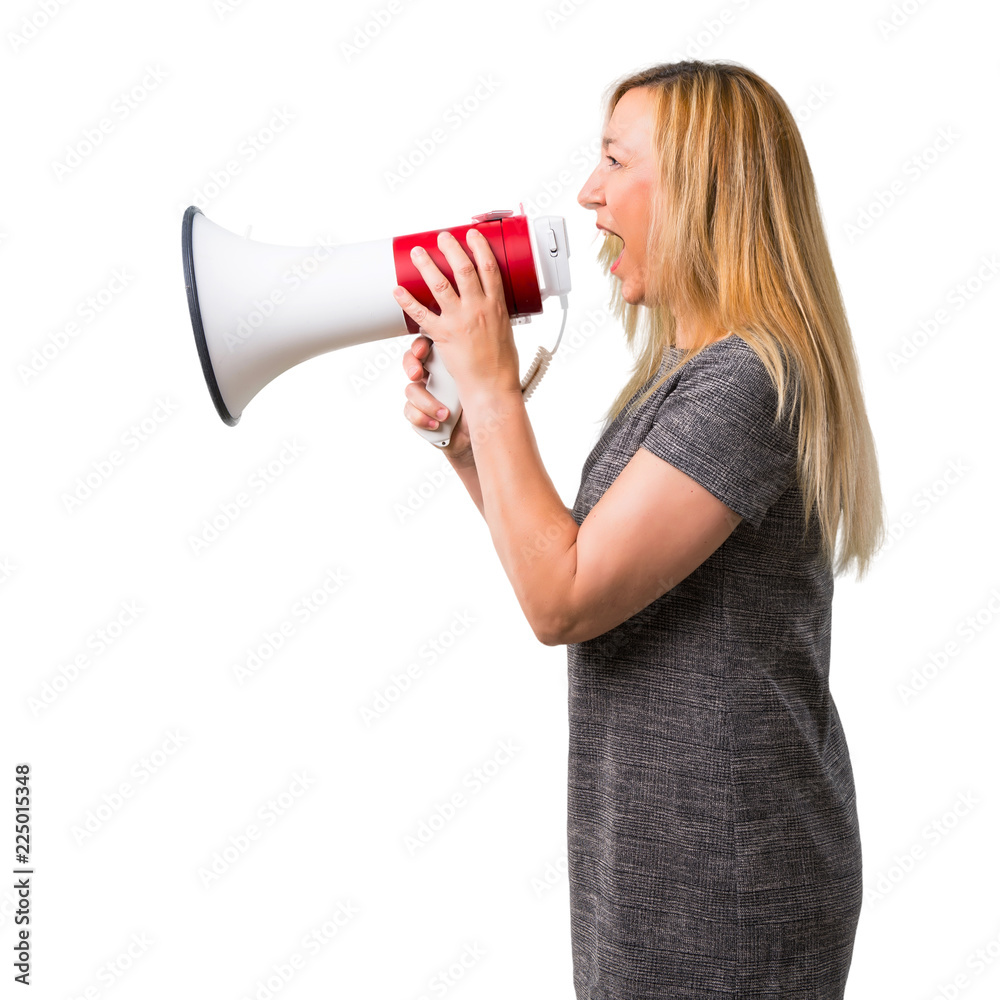 Middle-age blonde woman shouting through a megaphone to announce something in lateral position on isolated white background Middle-age blonde woman shouting through a megaphone to announce something in lateral position on isolated white background