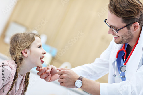 Little girl in clinic having a checkup with laryngologist