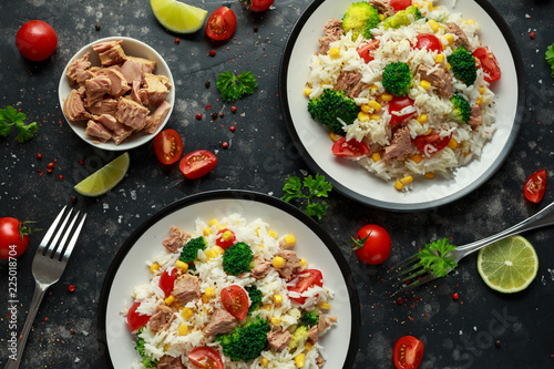 Fresh Tuna rice salad with sweet corn, cherry tomatoes, broccoli, parsley and lime in black bowl