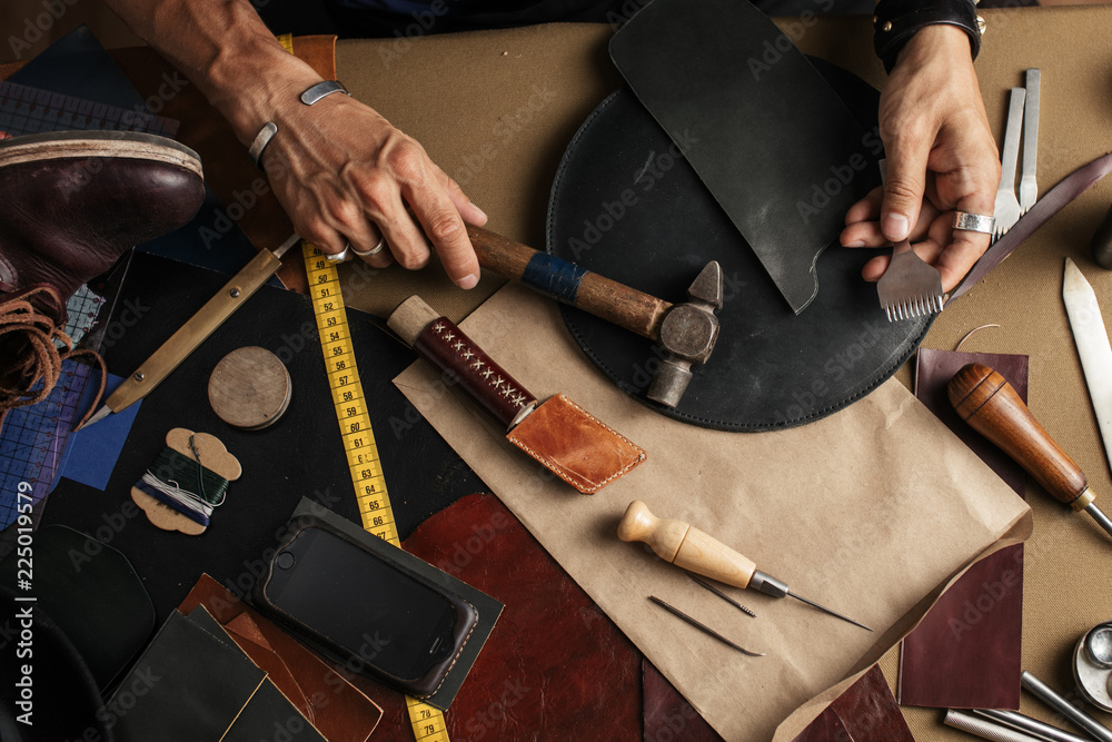 Top view of male shoemaker hands holding cobbler tools for making new