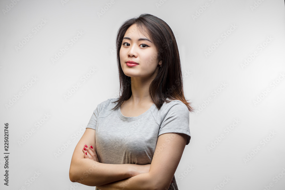 Φωτογραφία Confident sensual young Korean woman with long hair, dressed in white t-shirt looking at camera over white background
