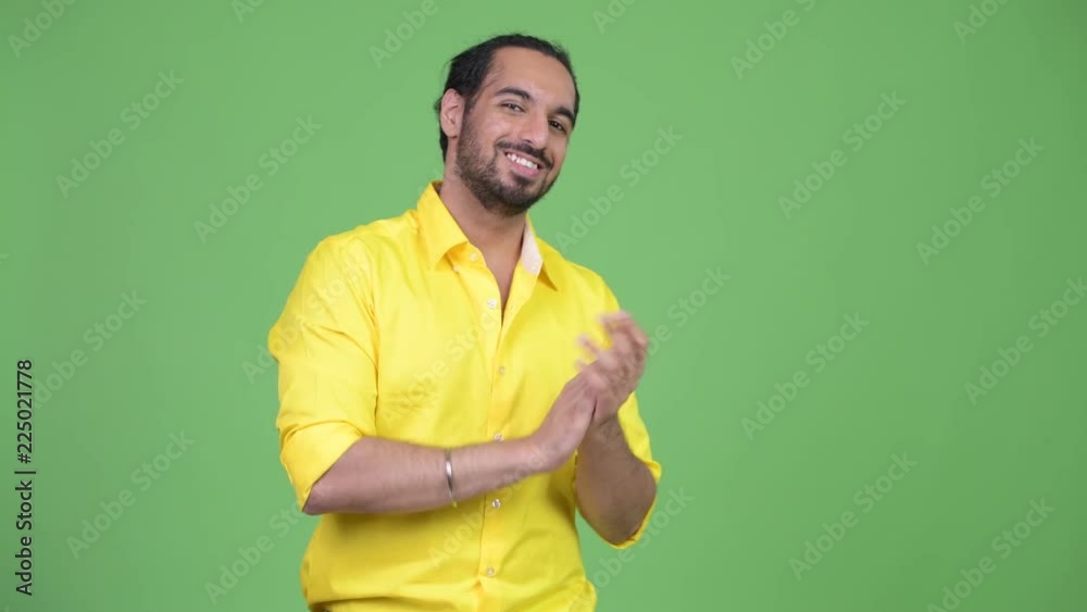 Young happy bearded Indian businessman clapping hands Young happy bearded Indian businessman clapping hands
