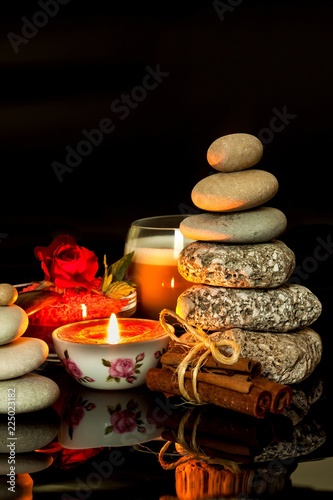 Pyramid of pebbles. Stones on the table. Rest for coffee. Wellness concept. Meditation with a candle.