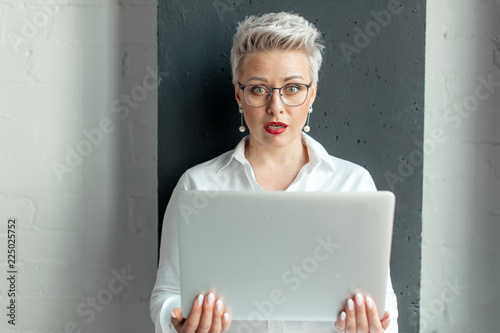 Canvas Print Surprised shoked woman reading unexpected information in laptop with open mouth